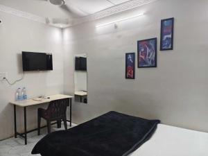 ビラースプルにあるHotel O Luxelineのベッド、机、テレビのある寝室