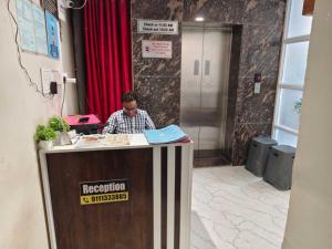 ビラースプルにあるHotel O Luxelineの事務所の受付に座る男