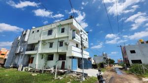 a white building on the side of a street at Hotel O SSR residency in Chennai