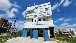 a white building with blue doors on a street at Hotel O SSR residency in Chennai
