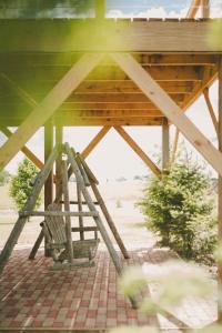 a wooden picnic table with a bench under a roof at Converted Grain Silo for Unique Glamping Accommodation in Alvin, Illinois in Alvin