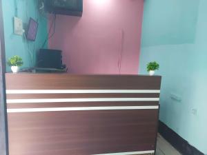 a brown and wooden door with two potted plants on top at Hotel O SUNLEAF GUEST HOUSE in Dispur