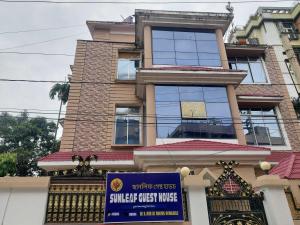 a large building with a sign in front of it at Hotel O SUNLEAF GUEST HOUSE in Dispur