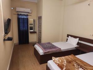 a small room with a bed and a television at Hotel O SUNLEAF GUEST HOUSE in Dispur