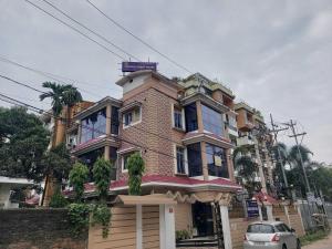 a building with a car parked in front of it at Hotel O SUNLEAF GUEST HOUSE in Dispur