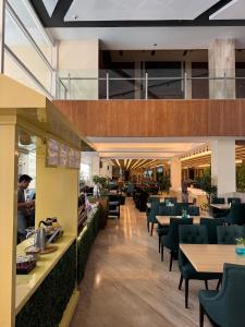 BagamAston Apartment 16-07的一家有桌椅和背景人物的餐厅