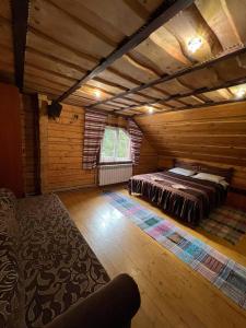 a large room with a bed in a log cabin at Лісова тиша Сімейні номера in Synevyrsʼka Polyana +9 photos