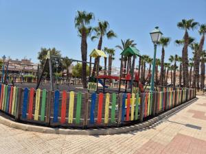 ein Zaun aus Büchern in einem Park mit einem Spielplatz in der Unterkunft Casa Flamingo - Corner house near beach & boulevard with sea & salt lake view in San Pedro del Pinatar
