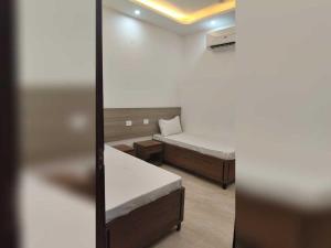 a small room with two beds and a mirror at Hotel O Lavish Hotel in Greater Noida