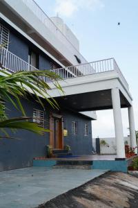 a blue building with a balcony and a porch at ll EMPYREAN STAY ll FLAGSHIP INN ll DOUBLE ROOM ll in Lonavala