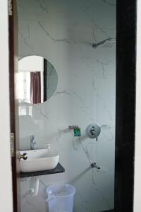a white bathroom with a sink and a mirror at ll EMPYREAN STAY ll FLAGSHIP INN ll DOUBLE ROOM ll in Lonavala