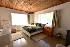 a bedroom with a bed and a window and a tub at Green Escape-Entire House in Moldoveneşti