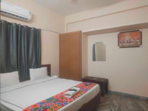 a hotel room with a bed with a phone on it at HOTEL O THE HOTEL TRIYA in Warangal