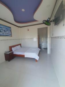 een slaapkamer met een bed en een flatscreen-tv bij Nhà Nghỉ Việt Thắng Dinh Thầy Thím in La Gi