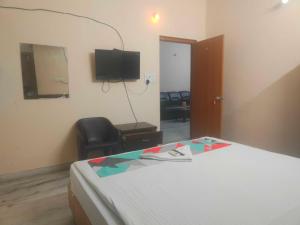 a hotel room with a bed and a television at HOTEL O THE HOTEL TRIYA in Warangal