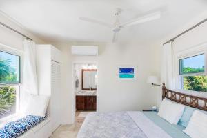 a bedroom with a bed and a bathroom with a sink at Chuchubi Cottage in Long Bay Hills