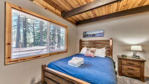 una camera da letto con un letto blu e una finestra di COH0809 - Brule Haven home a Lake Tahoe Airport