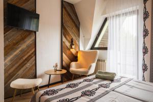 a bedroom with a bed and a chair and a television at Willa Józef in Zakopane +84 photos