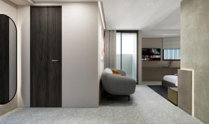 a living room with a chair and a bedroom at SUPERB HoTEL in Magong