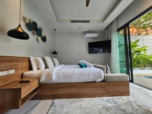une chambre avec un lit et une télévision au mur dans l'établissement Nicky Villa Luxury Private Haven in BangTao Laguna, à Laguna Phuket 43 autres photos