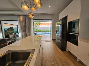 une cuisine avec un évier et un plan de travail dans l'établissement Nicky Villa Luxury Private Haven in BangTao Laguna, à Laguna Phuket