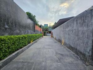 une allée entre deux grands murs de soutènement dans l'établissement Nicky Villa Luxury Private Haven in BangTao Laguna, à Laguna Phuket