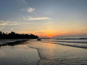 een zonsondergang op een strand met het tij op komst bij Nhà Nghỉ Việt Thắng Dinh Thầy Thím in La Gi