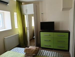 a bedroom with a green dresser and a television at Spital 1 cameră studio in Târgu-Mureş