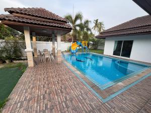 a swimming pool with a slide next to a house at Gmob Pool Villa Resort in Ban Map Fakthong