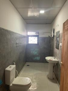 un baño con inodoro y lavabo en Kuma Surf Camp Hostel, en Weligama