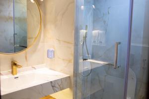 a bathroom with a shower and a sink and a mirror at Paradise Found in Dhigurah +37 photos