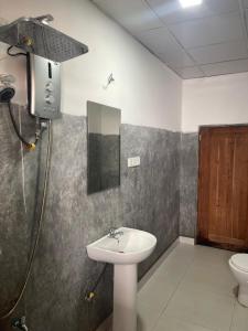un baño con lavabo e inodoro en Kuma Surf Camp Hostel, en Weligama