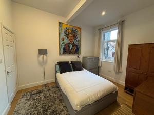 a bedroom with a bed and a painting on the wall at Bedford Guesthouse in Liverpool