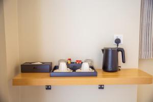 a counter with a coffee maker on a shelf at Paradise Found in Dhigurah