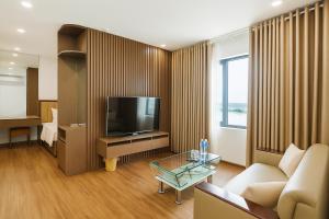 a living room with a couch and a television at Glory Hotel Apartment Hải Phòng in Hai Phong