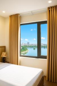 ハイフォンにあるGlory Hotel Apartment Hải Phòngの川の景色を望む窓付きのベッドルーム1室