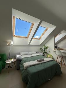 a bedroom with two beds and two windows at La Buhardilla in Moya