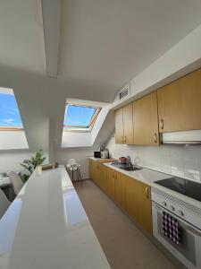 a kitchen with a counter top and two windows at La Buhardilla in Moya