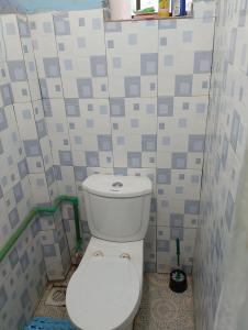 a bathroom with a white toilet in a room with tiles at Sacred Heart Apartments BNB & Hostels Meru Town in Meru