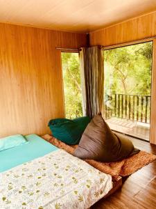 een slaapkamer met een bed en een raam met uitzicht bij Hill Top Haven Homestay in Phan Thiet