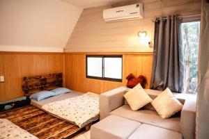 een woonkamer met een bank en een bed bij Hill Top Haven Homestay in Phan Thiet