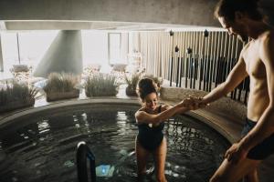 a woman in a bathing suit standing in a swimming pool at Villa Palenk Logar Valley in Solčava