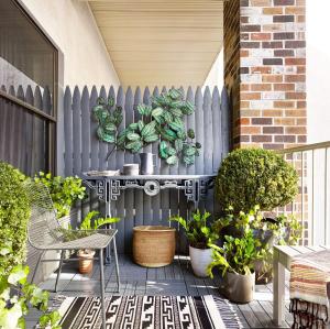a patio with a fence and a table with plants at HOTEL SUN town in Ahmedabad