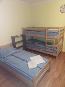 two bunk beds in a room with a clock on the wall at Apartmani Sumatra in Srebrenica