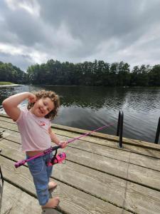 Una niña pequeña agarrada a una cuerda en un muelle en Dom na Mazurach Zatoka Leśna, en Wieniec 4 fotos más