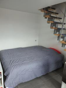 a bedroom with a bed and a staircase at DUPLEX BASSIN D'ARCACHON in Gujan-Mestras