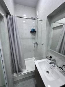 a white bathroom with a shower and a sink at BEERloga in Samarkand