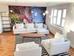 a living room with white couches and a table at Hotel Nova Limbach in Limbach - Oberfrohna