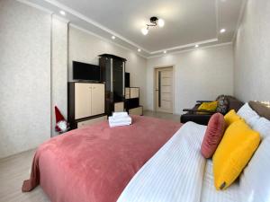 een slaapkamer met een groot bed met gele en rode kussens bij Комфортна 1к квартира в ЖК Лісовий Квартал in Brovary