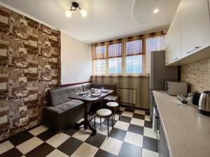 een keuken met een tafel en een bank in een kamer bij Комфортна 1к квартира в ЖК Лісовий Квартал in Brovary